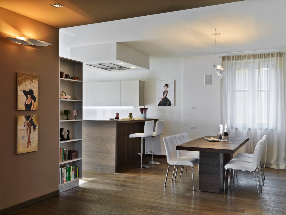 Exemple d'une salle à manger ouverte sur la cuisine tendance avec un mur blanc et parquet foncé.
