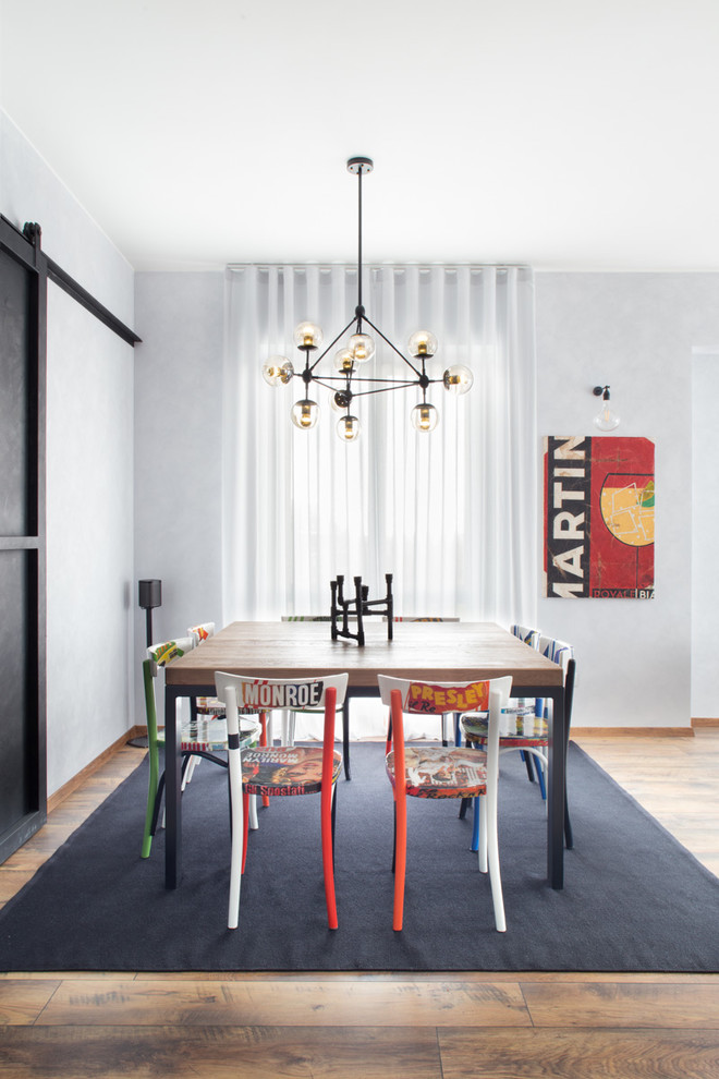 Idee per una sala da pranzo industriale con pavimento in legno massello medio e pareti grigie