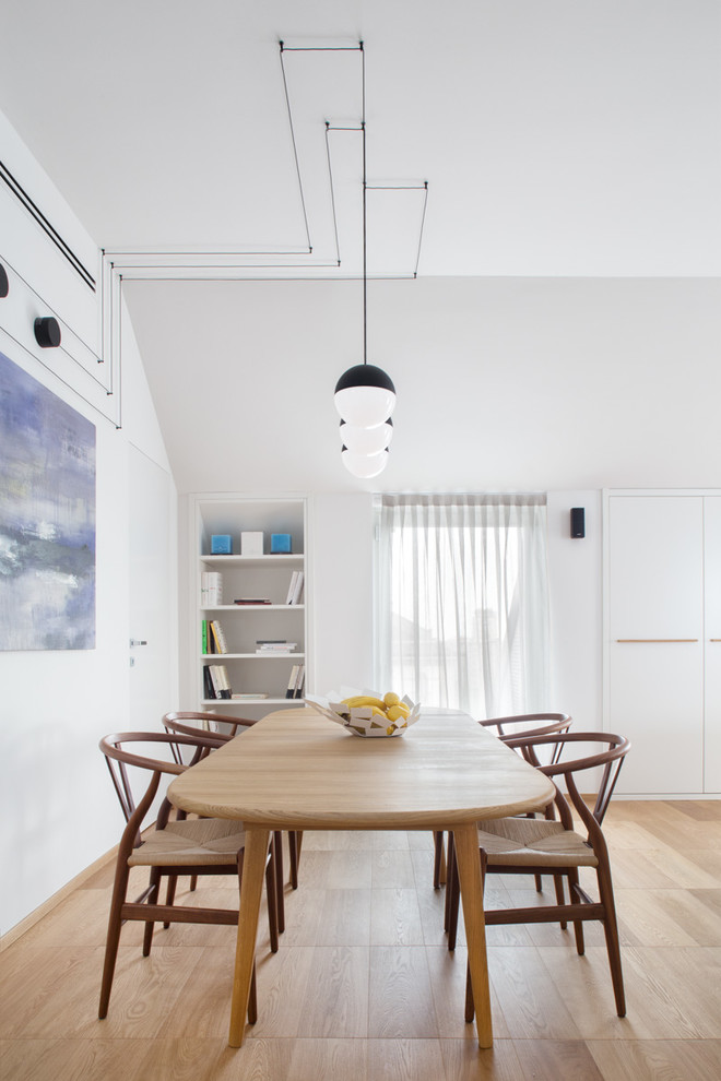 Immagine di una sala da pranzo aperta verso il soggiorno contemporanea con pareti bianche e pavimento in legno massello medio