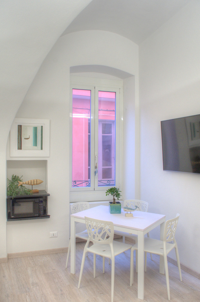 Ispirazione per una sala da pranzo aperta verso il soggiorno mediterranea con pareti bianche e pavimento in laminato
