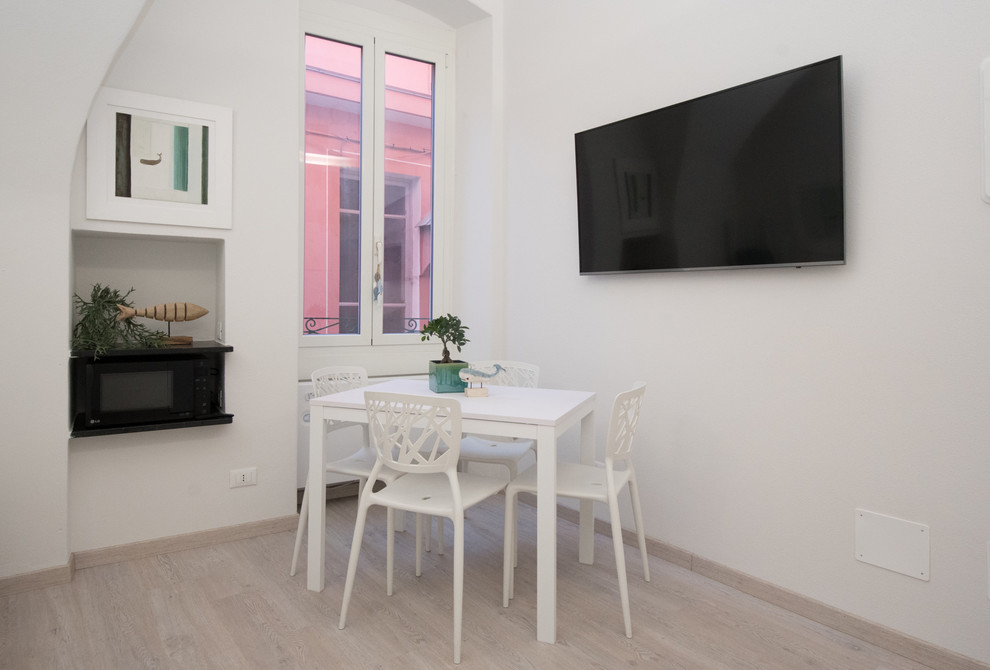 Свежая идея для дизайна: гостиная-столовая в средиземноморском стиле с белыми стенами и полом из ламината - отличное фото интерьера