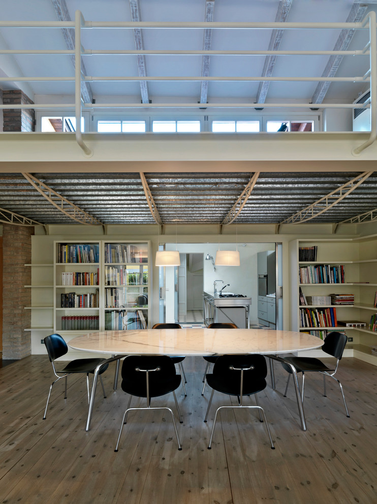 Esempio di una sala da pranzo aperta verso la cucina industriale con pavimento in legno massello medio e pareti bianche