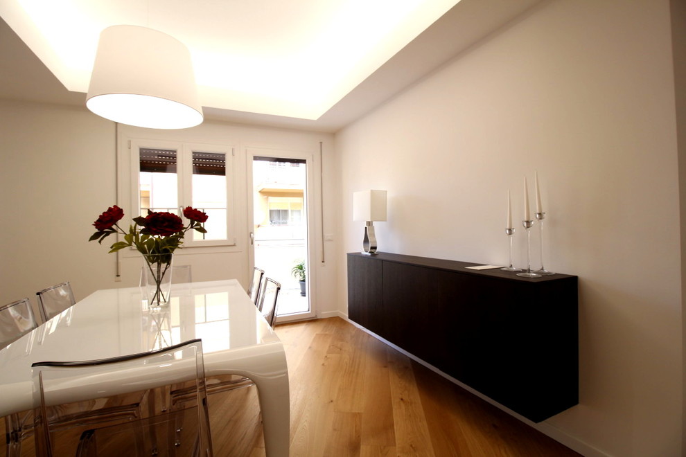 Exemple d'une salle à manger ouverte sur le salon tendance de taille moyenne avec un mur blanc et un sol en bois brun.
