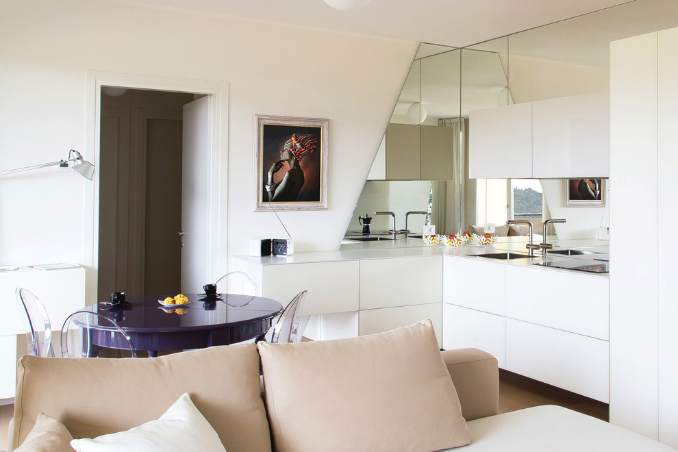 Esempio di una sala da pranzo aperta verso la cucina design con pareti bianche e parquet chiaro
