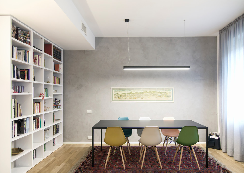 Immagine di una sala da pranzo aperta verso il soggiorno minimal di medie dimensioni con pareti grigie e parquet chiaro