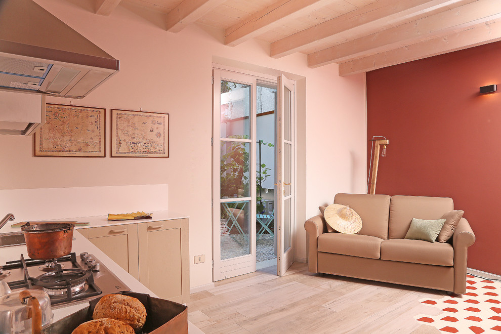 Kleine Landhausstil Wohnküche ohne Kamin mit bunten Wänden, Laminat und buntem Boden in Mailand