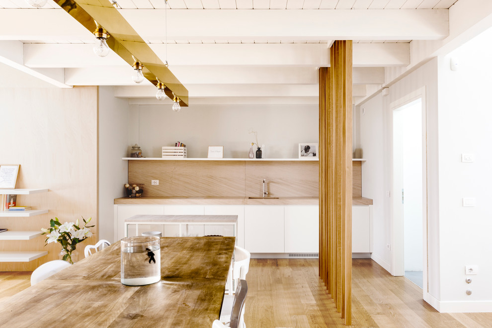 Immagine di una sala da pranzo minimal con pareti bianche, parquet chiaro e pavimento beige