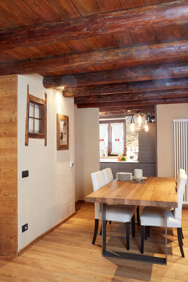 Imagen de comedor rural con paredes blancas y suelo de madera clara