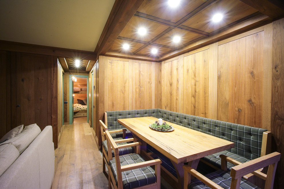 На фото: гостиная-столовая в стиле рустика с коричневыми стенами, паркетным полом среднего тона и коричневым полом