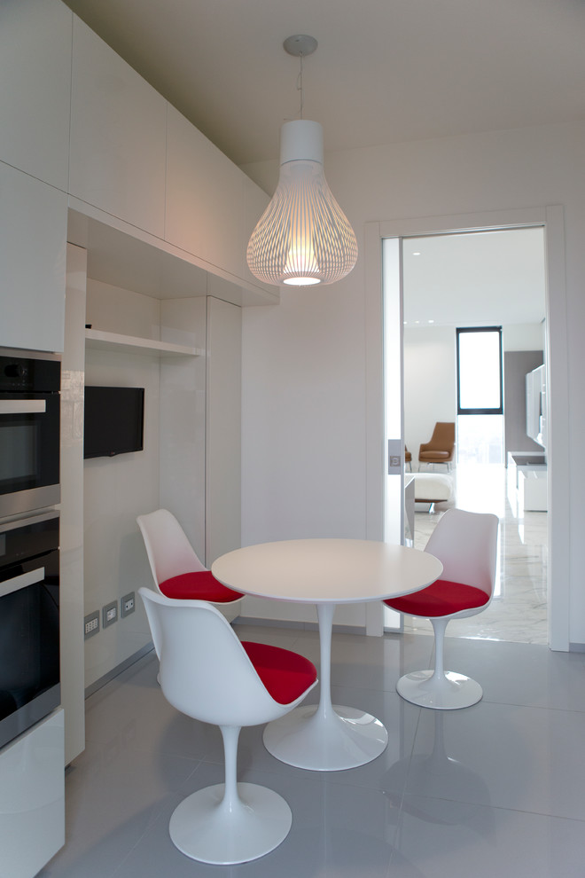 Réalisation d'une petite salle à manger ouverte sur la cuisine minimaliste avec un mur blanc et un sol en carrelage de porcelaine.