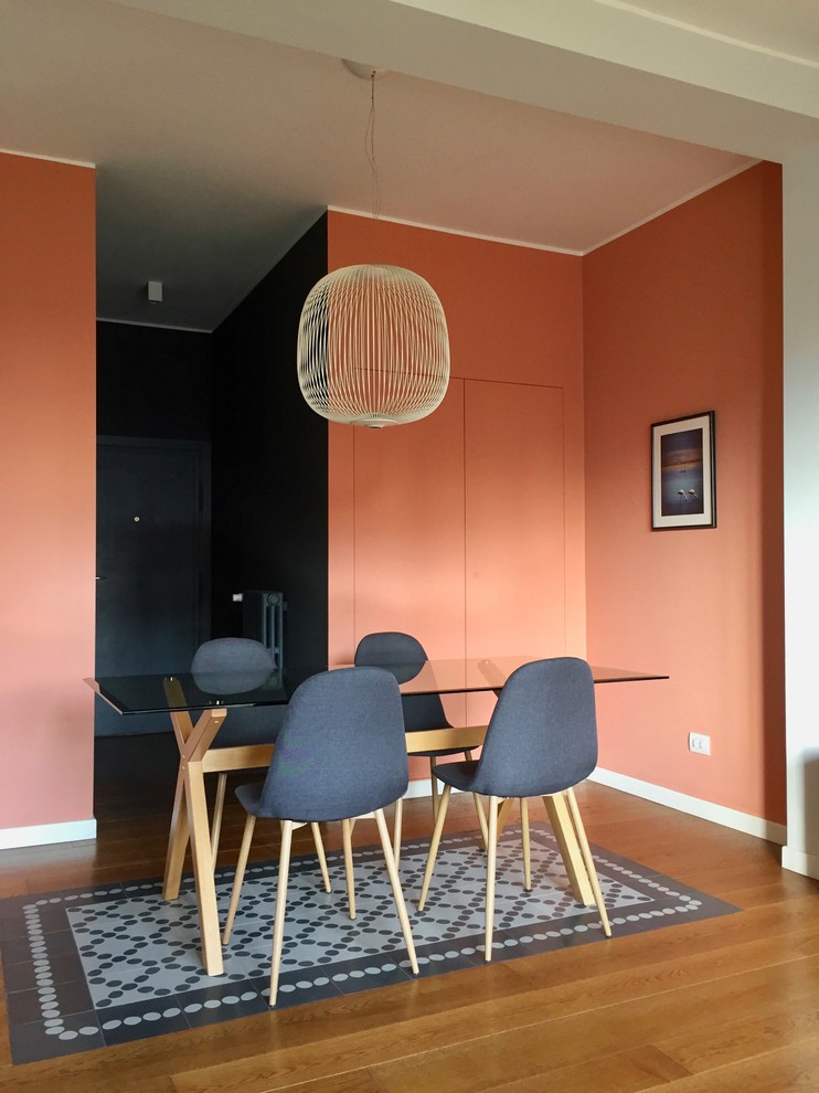 Exempel på en liten modern matplats med öppen planlösning, med orange väggar, mörkt trägolv och brunt golv