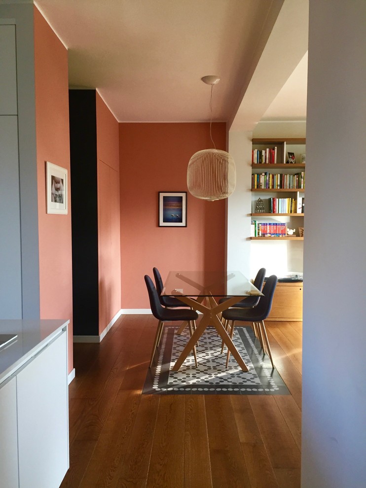 Imagen de comedor minimalista pequeño abierto con parades naranjas, suelo de madera oscura y suelo marrón
