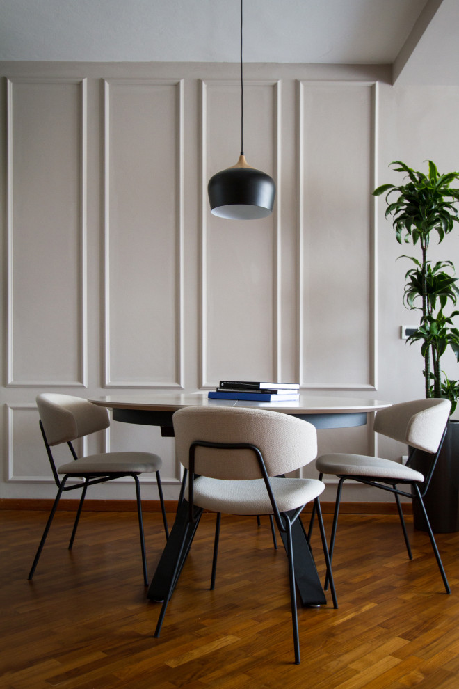 Cette photo montre une salle à manger tendance avec un mur gris, un sol en bois brun, un sol marron et du lambris.