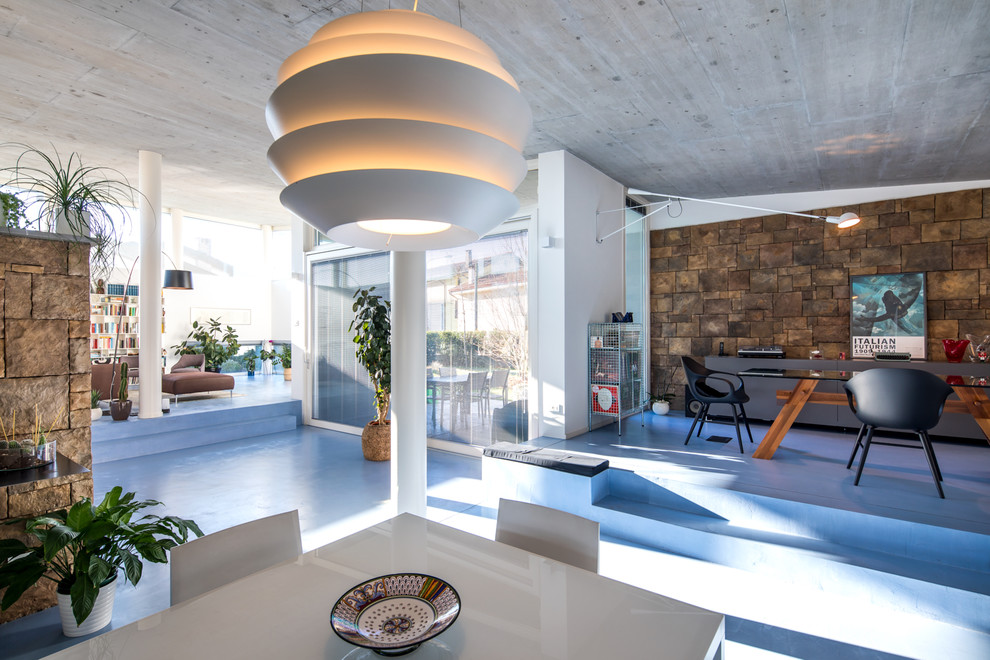 Immagine di una sala da pranzo aperta verso il soggiorno contemporanea con pareti bianche e pavimento blu