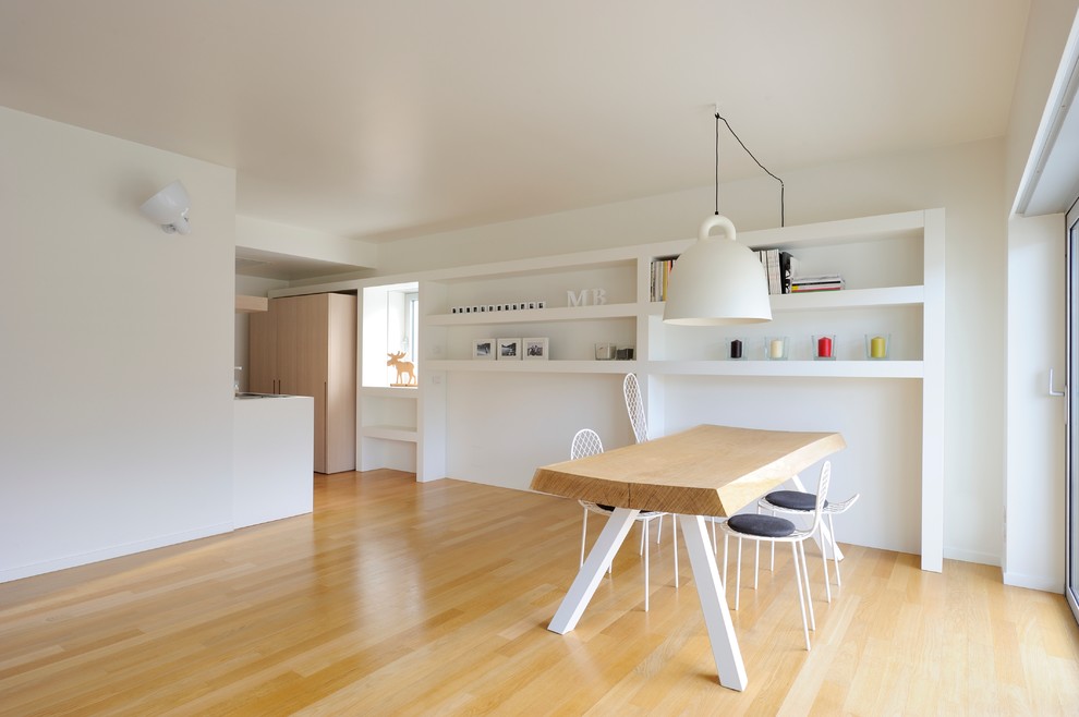 Foto på en mellanstor minimalistisk matplats med öppen planlösning, med vita väggar, ljust trägolv och beiget golv