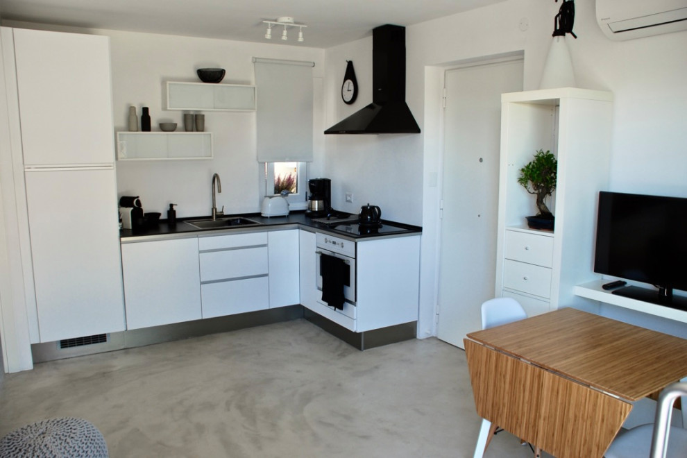Ispirazione per una piccola sala da pranzo aperta verso il soggiorno scandinava con pareti bianche, pavimento in cemento e pavimento grigio