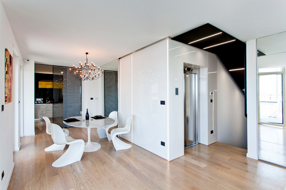 Esempio di una sala da pranzo aperta verso il soggiorno design di medie dimensioni con pareti bianche, pavimento in legno massello medio, nessun camino e pavimento marrone