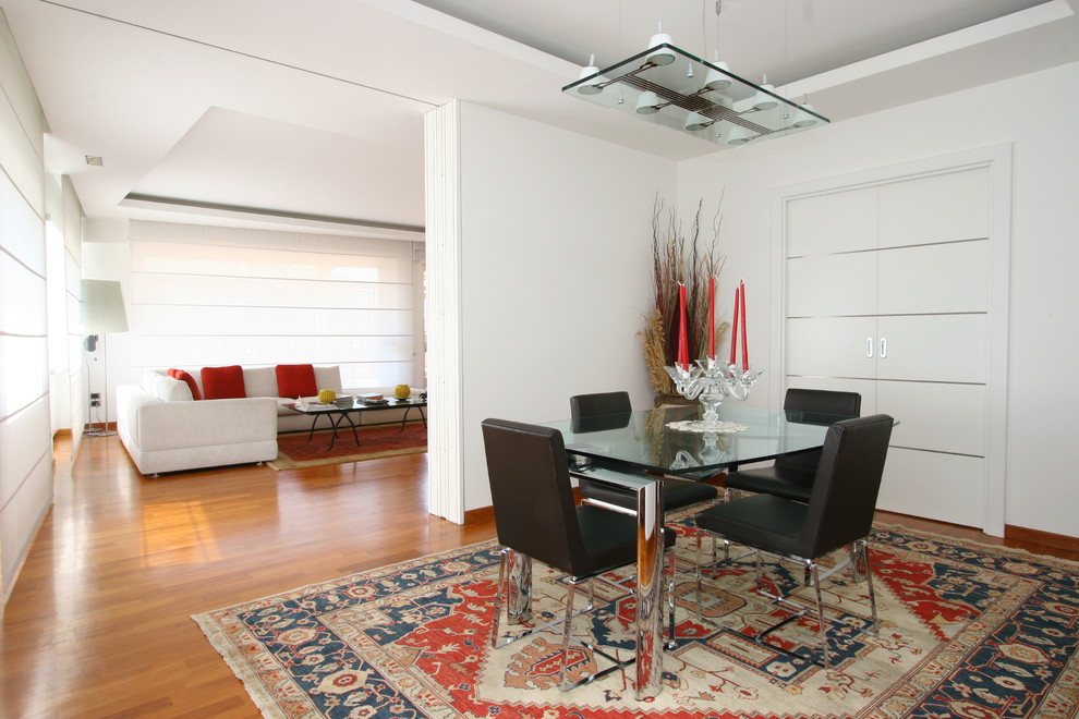 Inspiration pour une salle à manger ouverte sur le salon design avec un mur blanc et un sol en bois brun.