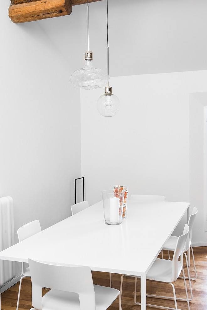 Immagine di una sala da pranzo aperta verso il soggiorno design di medie dimensioni con pareti bianche e parquet chiaro