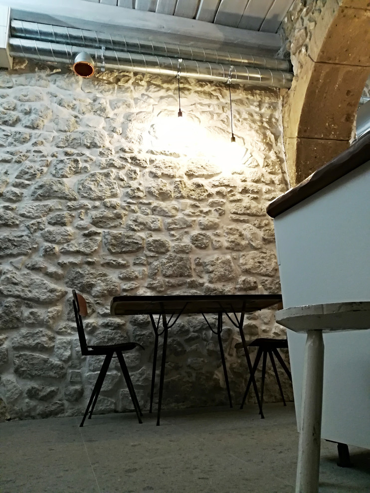 Idee per una piccola sala da pranzo aperta verso la cucina industriale con pareti grigie, pavimento in pietra calcarea e pavimento grigio