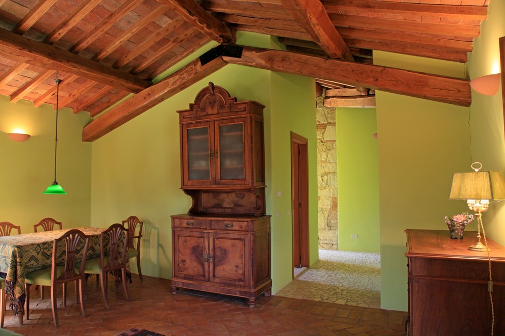 Idée de décoration pour une salle à manger ouverte sur le salon champêtre de taille moyenne avec un mur vert, tomettes au sol et un sol orange.
