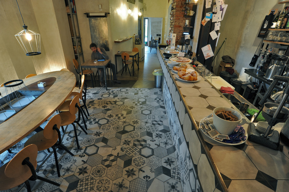 Foto på ett stort retro kök med matplats, med orange väggar och klinkergolv i porslin