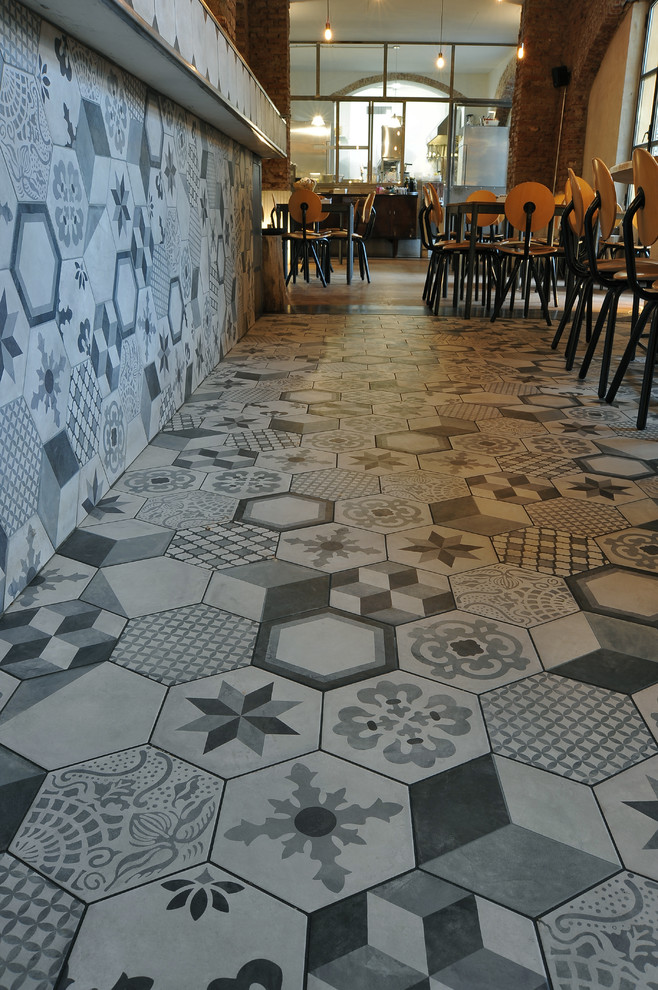Esempio di una grande sala da pranzo aperta verso la cucina moderna con pareti arancioni e pavimento in gres porcellanato