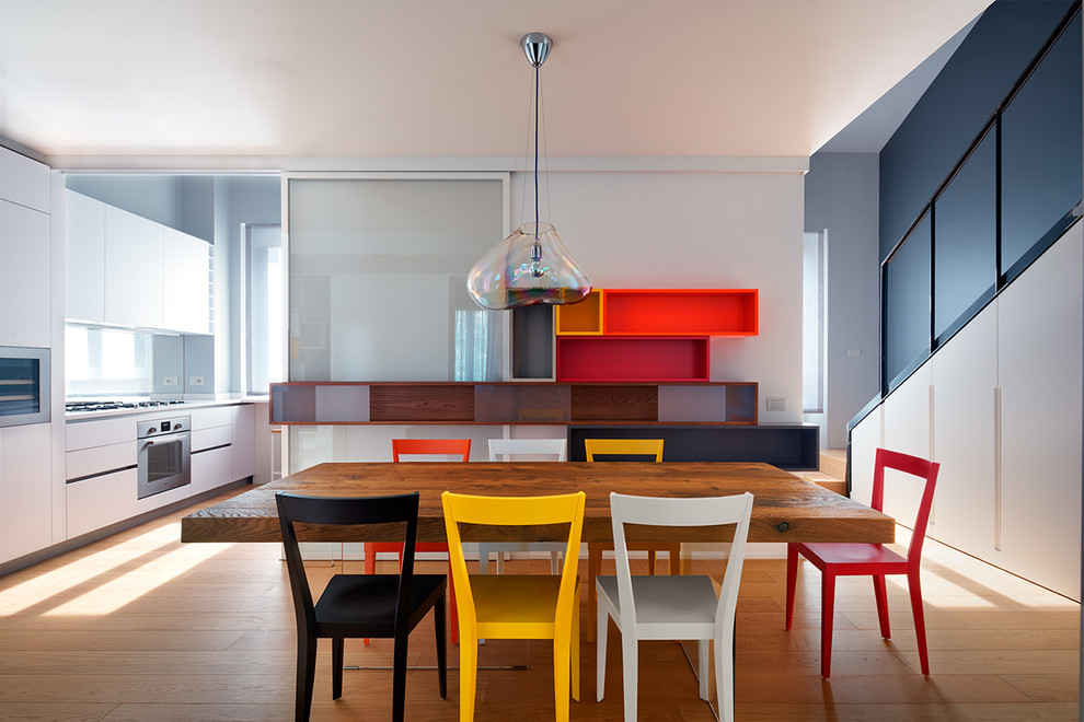 Immagine di una sala da pranzo aperta verso la cucina minimal di medie dimensioni con pareti grigie e parquet chiaro