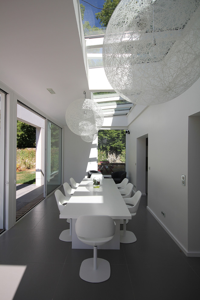Large contemporary enclosed dining room in Other with white walls.