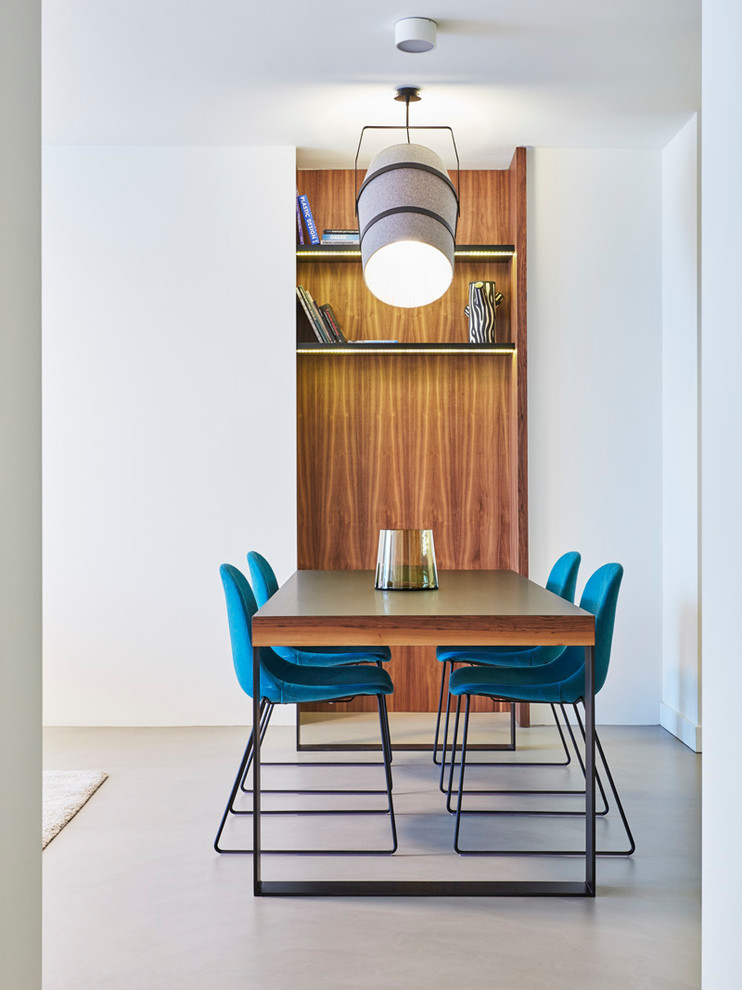 Esempio di una sala da pranzo aperta verso la cucina minimalista di medie dimensioni con pareti bianche, pavimento in cemento, nessun camino e pavimento grigio