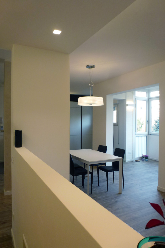 Foto di una sala da pranzo aperta verso il soggiorno minimal di medie dimensioni con pareti bianche, pavimento in gres porcellanato e pavimento marrone