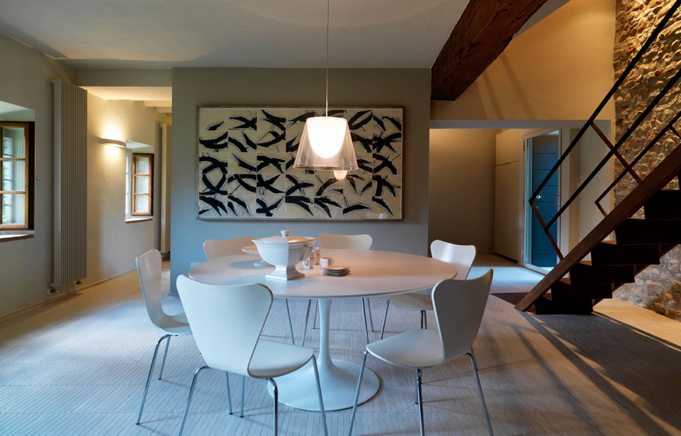 Immagine di una grande sala da pranzo aperta verso il soggiorno contemporanea con pareti grigie e parquet chiaro