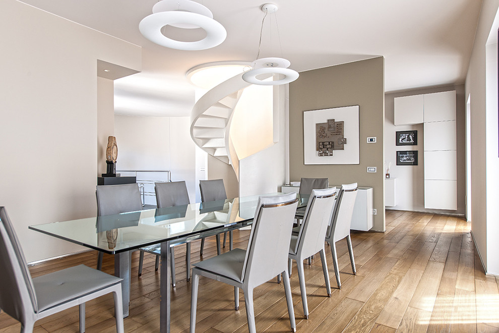 Immagine di una grande sala da pranzo aperta verso il soggiorno minimal con pareti beige e pavimento in legno massello medio