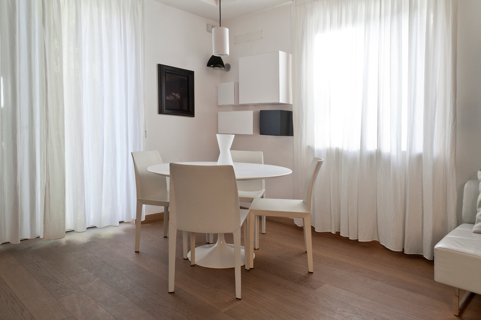 Immagine di una sala da pranzo aperta verso il soggiorno contemporanea di medie dimensioni con pareti bianche e parquet chiaro