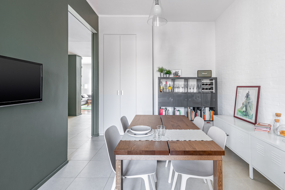 Ispirazione per una sala da pranzo aperta verso il soggiorno minimal di medie dimensioni con pareti verdi, pavimento in gres porcellanato, pavimento beige e pareti in mattoni