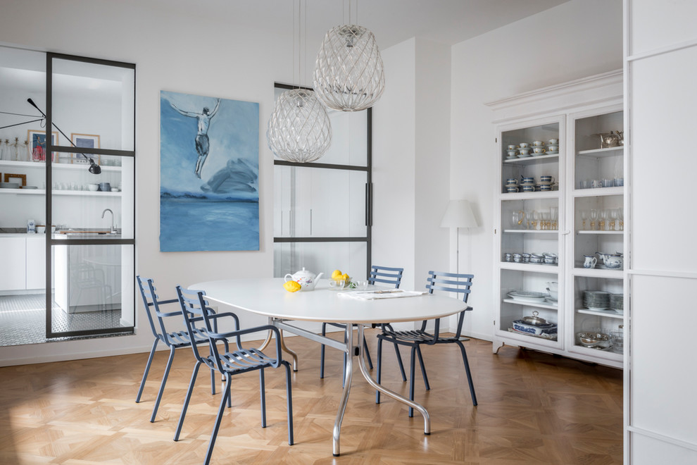 Idee per una sala da pranzo stile marinaro chiusa con pareti bianche, parquet chiaro e pavimento marrone
