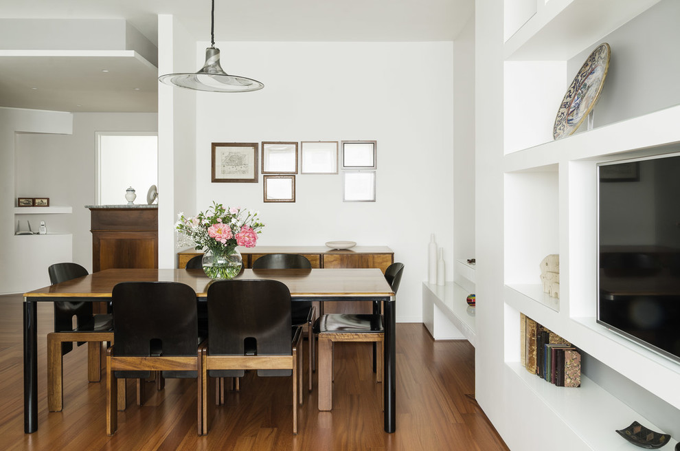 Idée de décoration pour une salle à manger ouverte sur le salon minimaliste avec un mur blanc et parquet foncé.