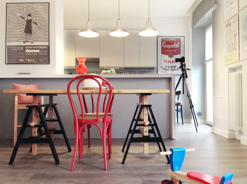 Ispirazione per una sala da pranzo aperta verso la cucina industriale di medie dimensioni con pareti bianche, pavimento in legno massello medio e pavimento marrone