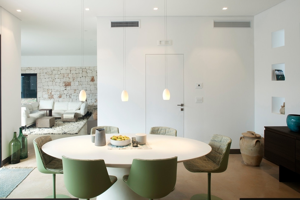 Modernes Esszimmer mit weißer Wandfarbe, beigem Boden und Betonboden in Sonstige