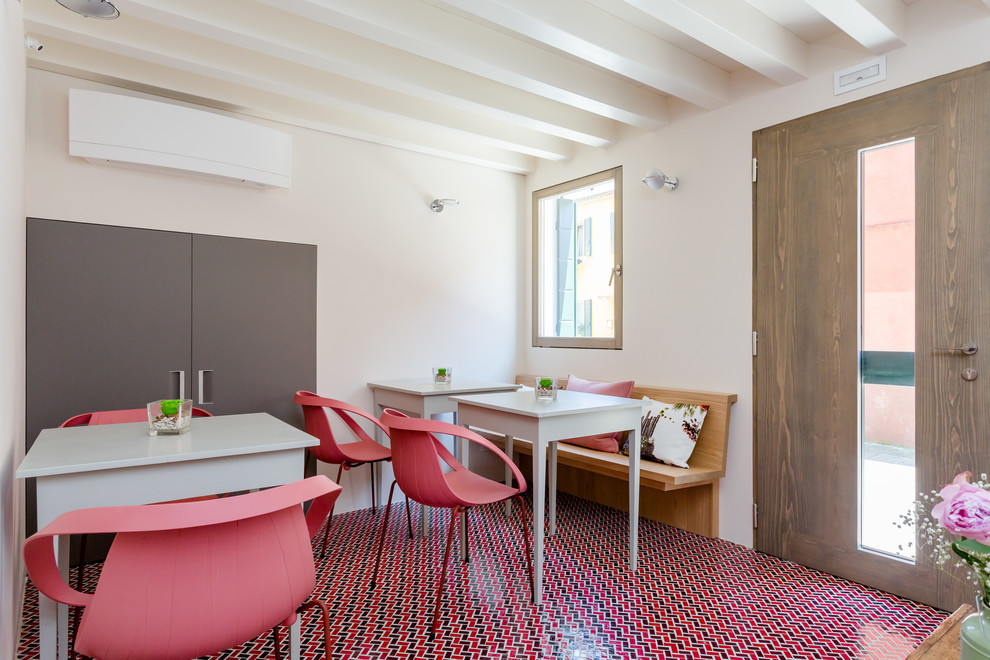 Idées déco pour une salle à manger méditerranéenne avec un mur blanc, un sol en carrelage de céramique et un sol rouge.