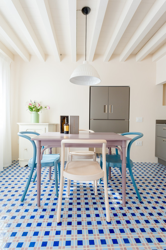 Immagine di una sala da pranzo aperta verso la cucina mediterranea con pareti bianche, pavimento con piastrelle in ceramica e pavimento blu