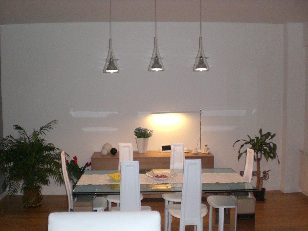Imagen de comedor moderno con paredes blancas y suelo de madera clara