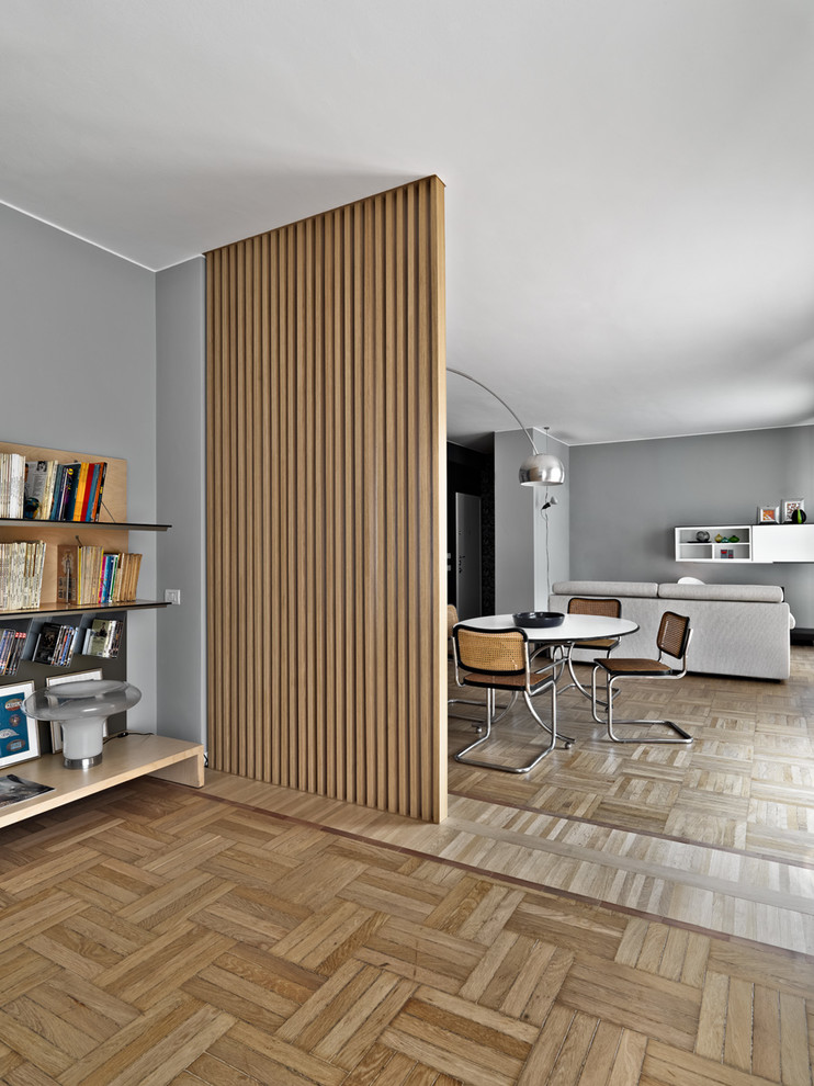 Modernes Esszimmer mit grauer Wandfarbe und hellem Holzboden in Mailand