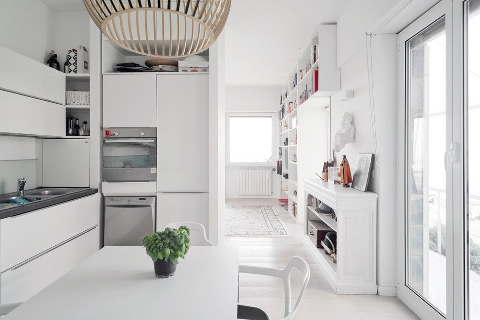 Ispirazione per una sala da pranzo aperta verso la cucina nordica di medie dimensioni con pareti bianche e parquet chiaro