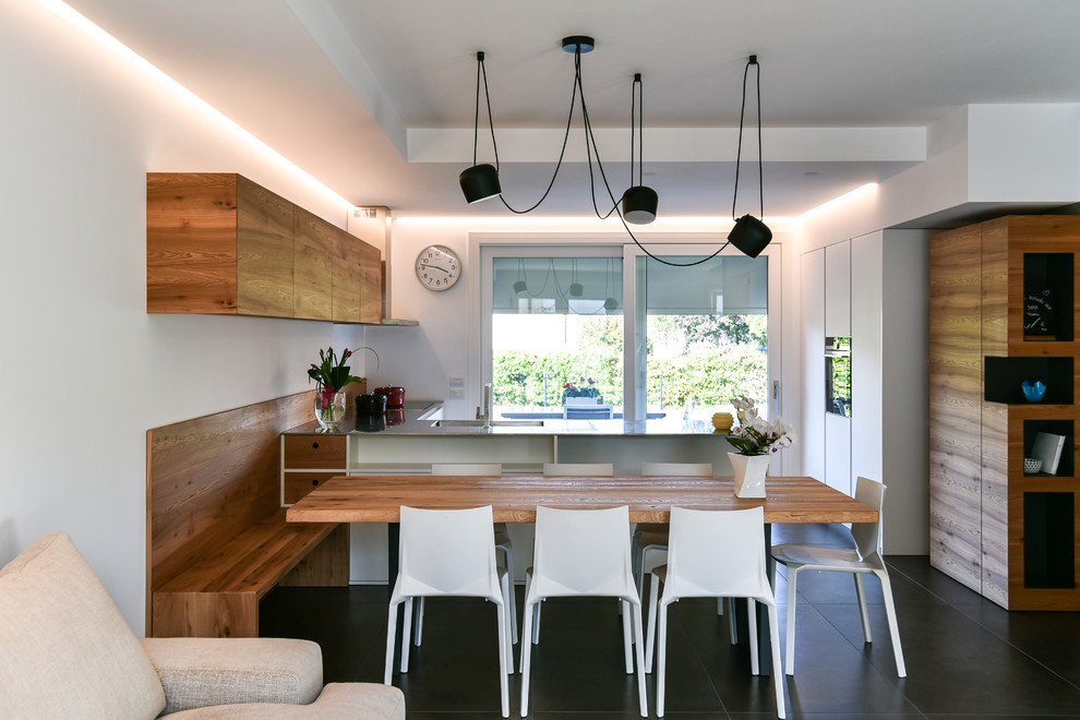 Exemple d'une grande salle à manger ouverte sur la cuisine tendance avec un mur blanc, un sol en carrelage de céramique et un sol noir.