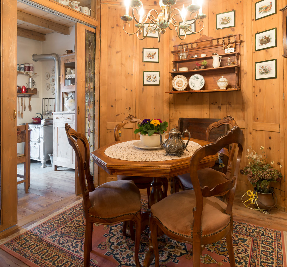 Cette image montre une petite salle à manger rustique fermée avec un mur marron, un sol en bois brun et un sol marron.