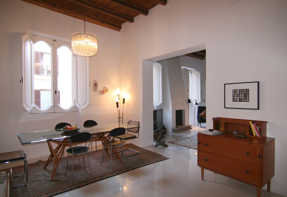 Ispirazione per una sala da pranzo aperta verso il soggiorno minimalista di medie dimensioni con pareti bianche, camino classico e cornice del camino in intonaco