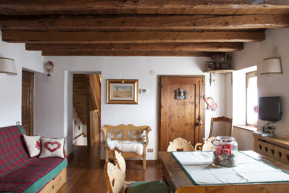 Inspiration pour une salle à manger ouverte sur le salon chalet de taille moyenne avec un mur marron, un sol en bois brun, un poêle à bois et un sol marron.
