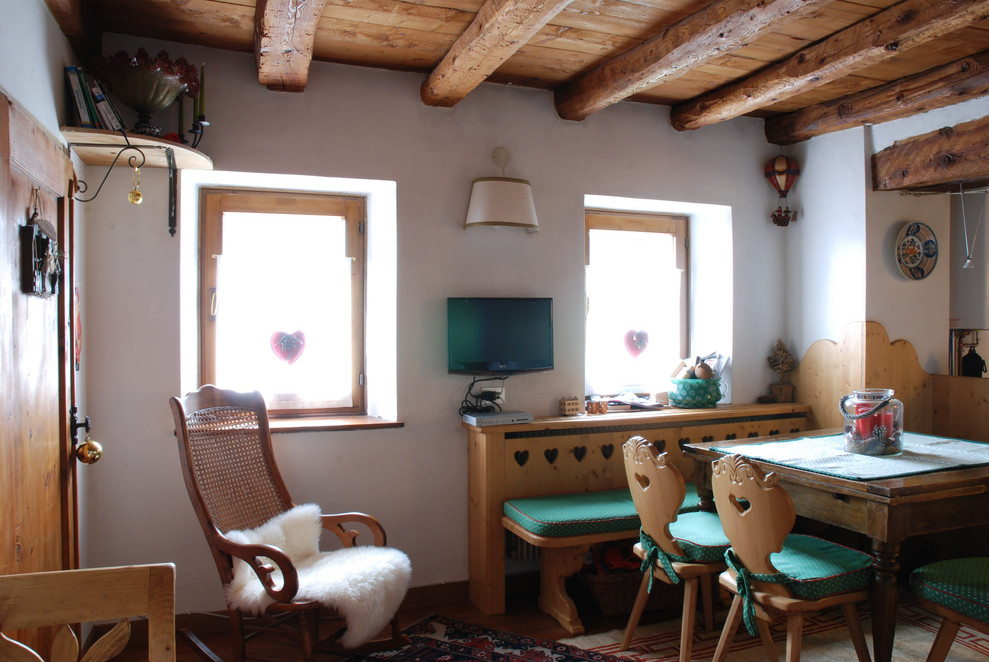 Ispirazione per una sala da pranzo rustica di medie dimensioni con pareti marroni, pavimento in legno massello medio, stufa a legna e pavimento marrone