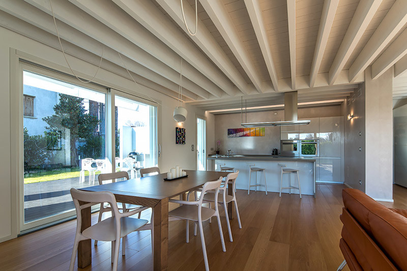 Offenes, Mittelgroßes Modernes Esszimmer mit weißer Wandfarbe, gebeiztem Holzboden, Hängekamin, verputzter Kaminumrandung und braunem Boden in Sonstige